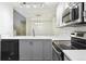 Well-lit kitchen features stainless steel appliances, gray cabinetry, and bright countertop at 703 S Depew St, Lakewood, CO 80226
