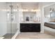 Modern bathroom featuring a glass-enclosed shower and dual sink vanity with ample lighting at 6777 Mariposa St, Denver, CO 80221