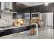 Modern kitchen featuring dark cabinets, granite countertops, and stainless steel appliances at 6777 Mariposa St, Denver, CO 80221