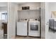Convenient laundry room featuring a washer, dryer, and built-in shelving at 6777 Mariposa St, Denver, CO 80221