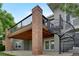 View of a home's back exterior, highlighting a deck with a spiral staircase and a brick support pillar at 1001 Deer Clover Way, Castle Pines, CO 80108