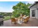 Relaxing outdoor deck with comfortable seating, a stylish rug, and views of the golf course and mature trees at 1001 Deer Clover Way, Castle Pines, CO 80108
