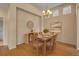 Dining room is set for six and features hardwood flooring, a modern light fixture, and decorative wall art at 1001 Deer Clover Way, Castle Pines, CO 80108