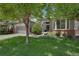 Charming home with a well-maintained lawn, mature trees, and an inviting entrance with ample natural light at 1001 Deer Clover Way, Castle Pines, CO 80108