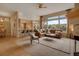 Open-concept living room features a fireplace, large windows and seamlessly connects to the kitchen and dining area at 1001 Deer Clover Way, Castle Pines, CO 80108
