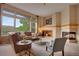 Bright living room with a fireplace, comfortable seating, and a view of the outdoor scenery at 1001 Deer Clover Way, Castle Pines, CO 80108