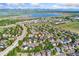 Aerial view of the neighborhood homes, roads, and nearby lake at 9821 Bucknell Ct, Highlands Ranch, CO 80129