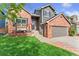 Charming two-story home showcasing a brick and gray exterior, an inviting entrance, and landscaped lawn at 9821 Bucknell Ct, Highlands Ranch, CO 80129