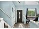 Inviting foyer with light blue walls, dark-stained front door, hardwood floors, and staircase at 9821 Bucknell Ct, Highlands Ranch, CO 80129