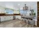 Bright eat-in kitchen with stone backsplash, breakfast bar and stainless steel appliances at 9821 Bucknell Ct, Highlands Ranch, CO 80129