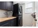 Laundry room with new stacked washer and dryer and folding table at 9821 Bucknell Ct, Highlands Ranch, CO 80129