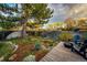 Lush backyard deck area with comfortable seating, beautiful landscaping, and mature shade trees at 1140 S Dover St, Lakewood, CO 80232