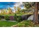 Green backyard features lush greenery, a well-maintained wooden fence, and mature trees at 1140 S Dover St, Lakewood, CO 80232