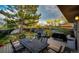 Charming backyard patio with a dining table, grill, and a large shade tree for outdoor enjoyment at 1140 S Dover St, Lakewood, CO 80232