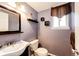 Powder room featuring modern fixtures, a dark wooden-framed mirror, and decorative shelving at 1140 S Dover St, Lakewood, CO 80232