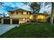 Charming two-story home with a well-manicured lawn, mature tree, and a two car garage at 1140 S Dover St, Lakewood, CO 80232
