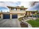 Charming two-story home with patio, chairs, landscaping, brick and a two-car garage at 1140 S Dover St, Lakewood, CO 80232