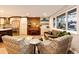 Bright living room with a brick accent wall, piano, and comfortable seating arrangement at 1140 S Dover St, Lakewood, CO 80232
