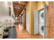 Hallway with hard wood floors and exposed beams with laundry in the hallway at 2960 Inca St # 317, Denver, CO 80202