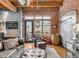 Living room boasts exposed brick walls, wood beams, and comfortable seating with an exterior view at 2960 Inca St # 317, Denver, CO 80202