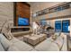 Elegant living room with stone fireplace, wood accent wall, and comfortable seating, adjacent to an open staircase at 5140 S Kearney Ct, Greenwood Village, CO 80111