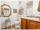 Small bathroom with toilet, vanity, and octagon mirror at 833 E 98Th Ave # 204, Thornton, CO 80229