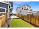 Fenced backyard with artificial grass and stone landscaping offers a low-maintenance and inviting outdoor space at 21413 E 59Th Pl, Aurora, CO 80019