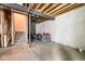 Spacious unfinished basement with exposed ceiling beams and open layout, offering potential for customization at 21413 E 59Th Pl, Aurora, CO 80019