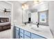 Well-lit bathroom boasts double sinks, quartz countertops, and modern fixtures, providing a sleek and functional space at 21413 E 59Th Pl, Aurora, CO 80019