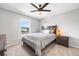 Bright bedroom featuring a cozy bed, side table with lamp, and view of the neighborhood at 21413 E 59Th Pl, Aurora, CO 80019