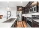 Elegant kitchen with stainless steel appliances, modern countertops, a stainless steel sink, and dark cabinets at 21413 E 59Th Pl, Aurora, CO 80019