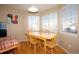 Cozy dining area featuring a wooden table and chairs, bathed in natural light from the surrounding windows at 11413 Oswego St, Commerce City, CO 80640