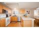 Well-lit kitchen featuring stainless steel appliances, light wood cabinets, and a cozy breakfast nook at 11413 Oswego St, Commerce City, CO 80640