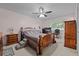Comfortable bedroom with wooden bed frame, ceiling fan, and a well-lit workspace by the window at 4550 E 121St Pl, Thornton, CO 80241