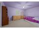 Bright bedroom with purple walls, large window, and matching wooden furniture at 4550 E 121St Pl, Thornton, CO 80241