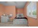 Calming bedroom in soft peach hues with a twin bed, bedside table, and a bright window at 4550 E 121St Pl, Thornton, CO 80241