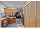 Functional kitchen with wooden cabinets, an oven, and adjacent access to the living room at 4550 E 121St Pl, Thornton, CO 80241