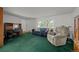 Bright and airy living room with vintage green carpet, a comfortable sofa, and a work desk at 4550 E 121St Pl, Thornton, CO 80241
