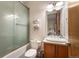 Bathroom includes a bathtub with glass doors, a modern vanity, and updated fixtures at 8071 E 29Th Ave, Denver, CO 80238