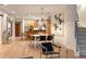 Open-concept dining room features modern light fixtures, light wood floors and a view into the kitchen at 8071 E 29Th Ave, Denver, CO 80238