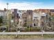 Overhead view of modern townhomes with rooftop decks, surrounded by manicured greenery and nearby amenities at 8071 E 29Th Ave, Denver, CO 80238