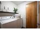 Well-lit laundry room with modern washer and dryer, shelving, and a sleek design at 8071 E 29Th Ave, Denver, CO 80238
