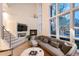 Cozy living room with fireplace, high windows, modern furnishings, and an open staircase at 8071 E 29Th Ave, Denver, CO 80238