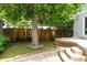 Serene backyard featuring a mature shade tree and an outdoor living area at 2485 S Fillmore St, Denver, CO 80210
