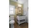 Stylish bathroom featuring a modern vanity, decorative mirror, and earth-tone tiled walls at 2485 S Fillmore St, Denver, CO 80210