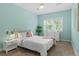 Bright bedroom featuring aqua colored walls, white trim, and lots of natural light from large window at 2485 S Fillmore St, Denver, CO 80210