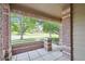 View from a covered front porch with brick columns, showcasing a lovely neighborhood scene at 6404 Silver Mesa Dr # E, Highlands Ranch, CO 80130