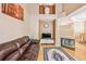 Cozy living room with hardwood floors, a fireplace, and an open layout to the kitchen and dining room at 6404 Silver Mesa Dr # E, Highlands Ranch, CO 80130