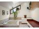 This bright bathroom features a large soaking tub and a window filled with hanging plants at 5812 Irish Pat Murphy Dr, Parker, CO 80134