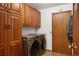 Convenient laundry room featuring a washer, dryer, and ample storage space with wood cabinets at 5812 Irish Pat Murphy Dr, Parker, CO 80134